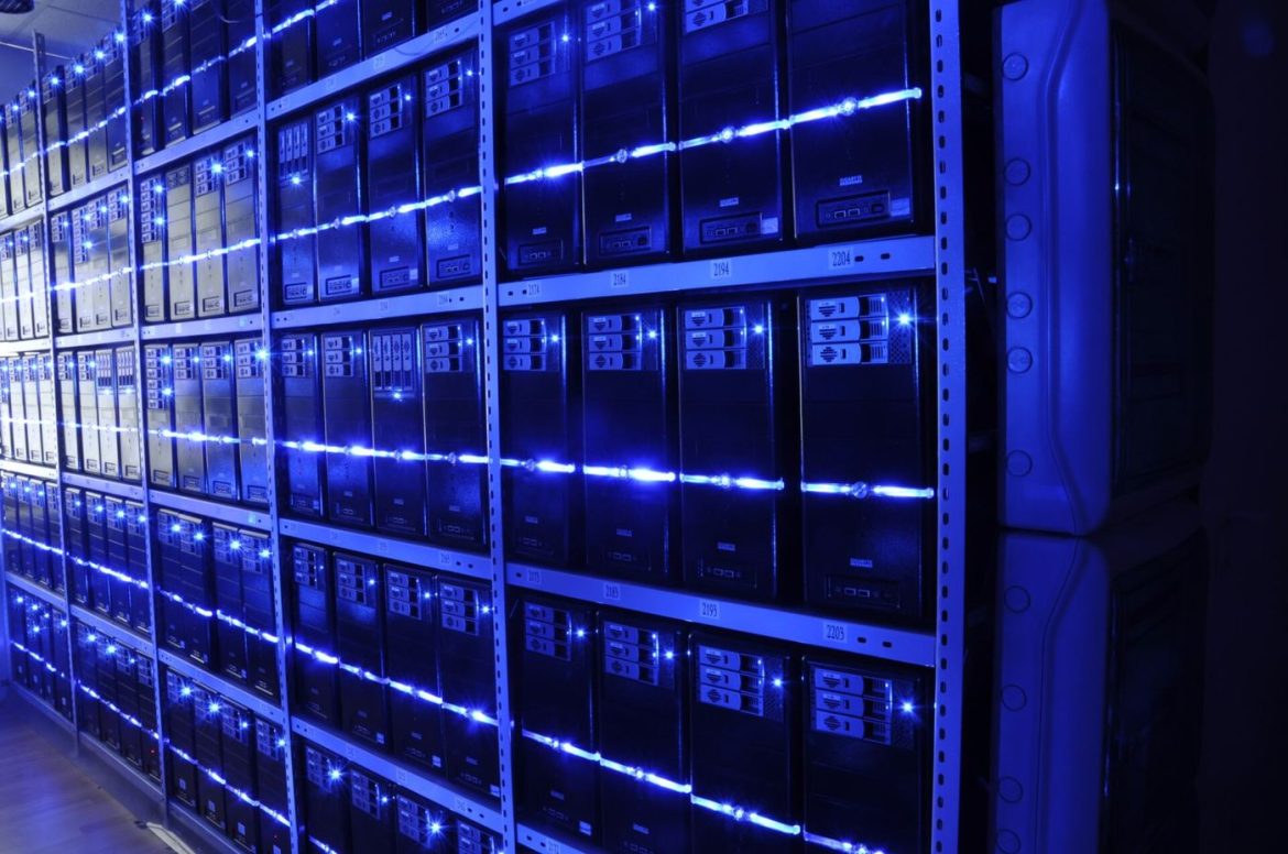 engineer inspecting server racks inside large data center